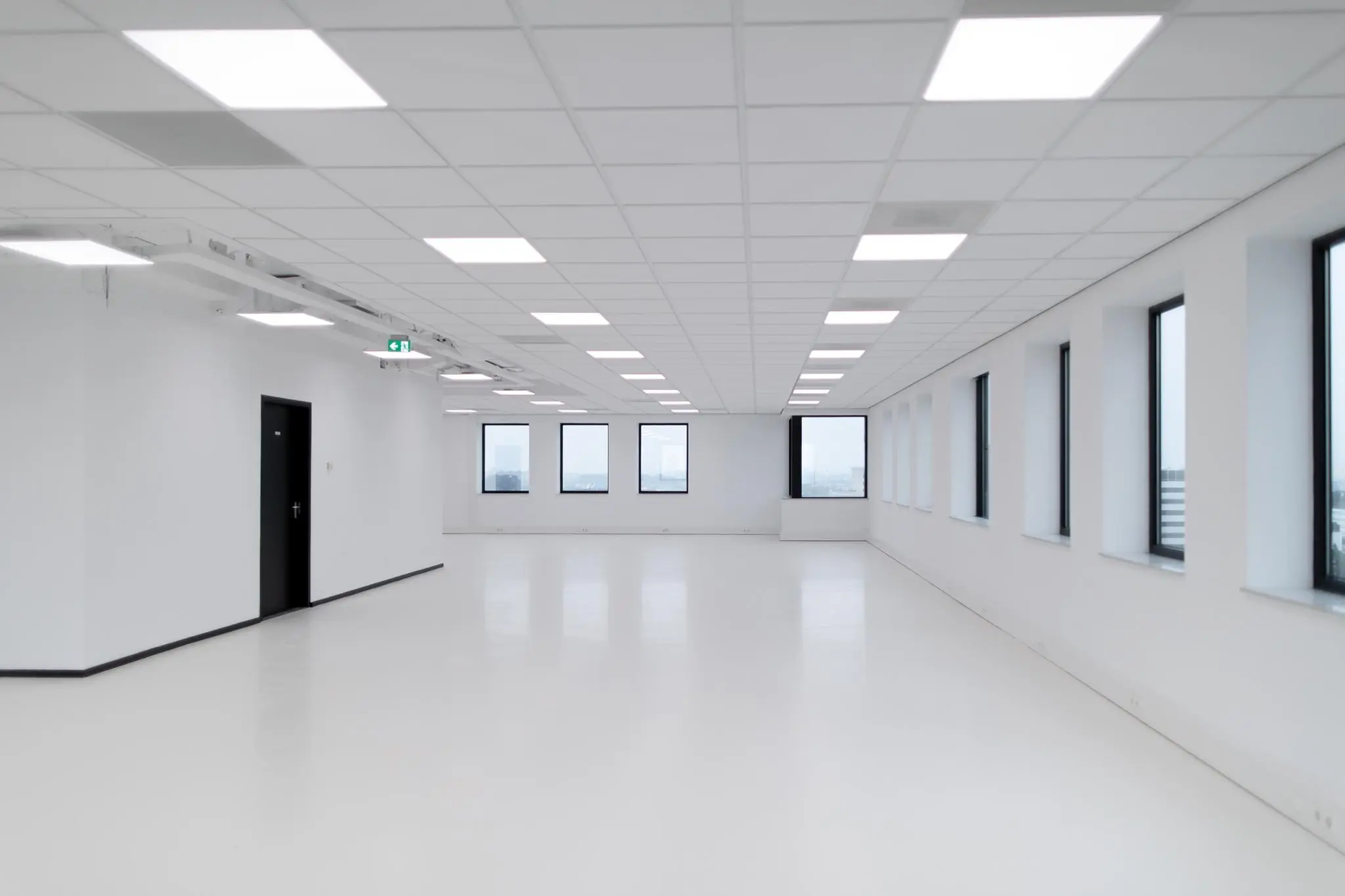 Lichte, lege kantoorruimte in Rivium Quadrant met grote ramen en systeemplafond.